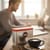 Nescafé Azera Barista-Style Instant Coffee 500g - Smooth & Rich Blend - pictured beside a cup of freshly brewed black coffee in a home office workspace with a man sitting at his desk.