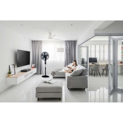 Air Comfort 40 pedestal fan cooling a bright modern living room